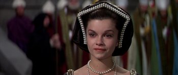 Movie still from “Anne of the Thousand Days” (1969), directed by Charles Jarrott – A young woman wearing a black and white dress and pearls; Close Up shot, High angle