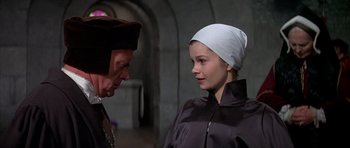 Movie still from “Anne of the Thousand Days” (1969), directed by Charles Jarrott – A man and a woman wearing hats in a room; Close Up shot, Over the shoulder angle