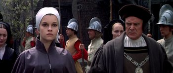 Movie still from “Anne of the Thousand Days” (1969), directed by Charles Jarrott – A group of people in medieval garb are standing together; Close Up shot, Over the shoulder angle