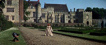 Movie still from “Anne of the Thousand Days” (1969), directed by Charles Jarrott – A woman in a long dress standing in front of a castle; Extreme Wide shot, High angle