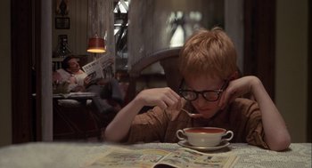 Movie still from “Annie Hall” (1977), directed by Woody Allen – A young boy sitting in front of a cup of coffee; Medium shot, High angle