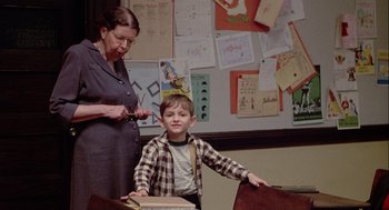 Movie still from “Annie Hall” (1977), directed by Woody Allen – A young boy standing next to an older woman; Medium shot, Over the shoulder angle