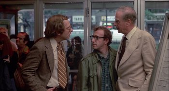 Movie still from “Annie Hall” (1977), directed by Woody Allen – A group of men standing next to each other in a room; Medium shot, Over the shoulder angle