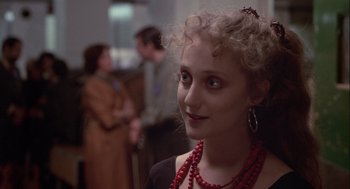 Movie still from “Annie Hall” (1977), directed by Woody Allen – A young woman with a red necklace is smiling for the camera; Close Up shot, Over the shoulder angle