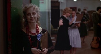 Movie still from “Annie Hall” (1977), directed by Woody Allen – A young girl in a black dress holding a book in her hand; Medium shot, Over the shoulder angle