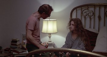 Movie still from “Annie Hall” (1977), directed by Woody Allen – A man and a woman sitting on a bed next to a lamp; Medium shot, High angle