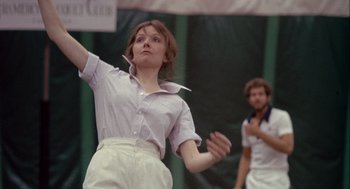 Movie still from “Annie Hall” (1977), directed by Woody Allen – A woman in white shirt and white pants playing tennis; Medium shot, Low angle