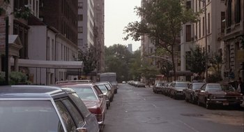 Movie still from “Annie Hall” (1977), directed by Woody Allen – Cars parked along a city street lined with tall buildings; Extreme Wide shot, High angle