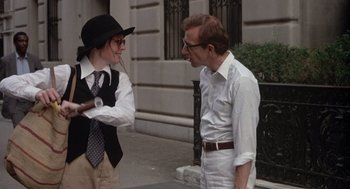 Movie still from “Annie Hall” (1977), directed by Woody Allen – A man and a woman standing next to each other on the sidewalk; Medium shot, Over the shoulder angle