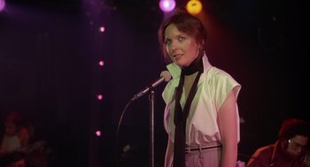 Movie still from “Annie Hall” (1977), directed by Woody Allen – A woman standing in front of a microphone on a stage; Medium shot, Over the shoulder angle
