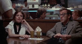 Movie still from “Annie Hall” (1977), directed by Woody Allen – A man and a woman sitting at a table with drinks in front of them; Medium shot, Over the shoulder angle