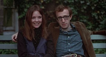 Movie still from “Annie Hall” (1977), directed by Woody Allen – A man and a woman sitting next to each other on a bench; Medium shot, Low angle