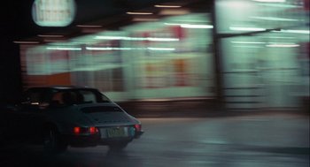 Movie still from “Annie Hall” (1977), directed by Woody Allen – A car driving down a street at night time; Wide shot, High angle