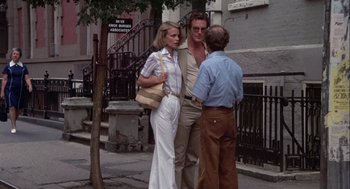 Movie still from “Annie Hall” (1977), directed by Woody Allen – A man and a woman standing next to each other on the sidewalk; Wide shot, Low angle
