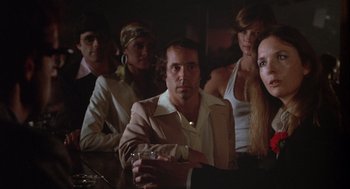 Movie still from “Annie Hall” (1977), directed by Woody Allen – A group of men and women sitting at a bar; Medium shot, Low angle