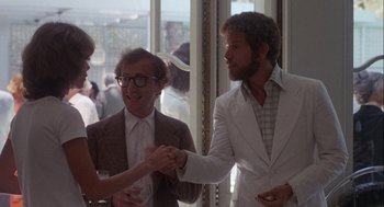 Movie still from “Annie Hall” (1977), directed by Woody Allen – Two men and a woman shaking hands at an event; Medium shot, Over the shoulder angle