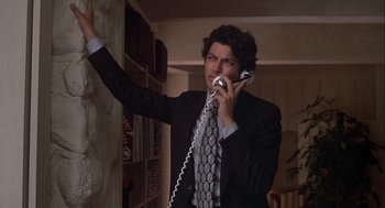 Movie still from “Annie Hall” (1977), directed by Woody Allen – A man in a suit and tie holding a phone to his ear; Close Up shot, Low angle