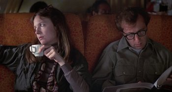 Movie still from “Annie Hall” (1977), directed by Woody Allen – A woman sitting next to a man on a train; Medium shot, Over the shoulder angle