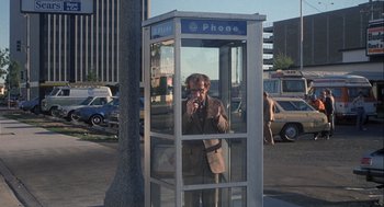 Movie still from “Annie Hall” (1977), directed by Woody Allen – A man standing in a phone booth talking on the phone; Wide shot, Low angle