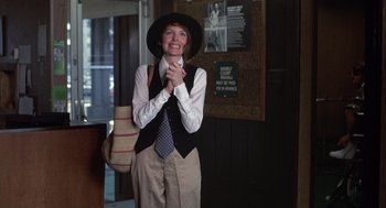 Movie still from “Annie Hall” (1977), directed by Woody Allen – A woman wearing a hat and holding her hands in front of her face; Medium shot, Low angle