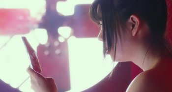 Movie still from “Antiporno” (2016), directed by Sion Sono – A woman looking at a cell phone; Extreme Close Up shot, Low angle