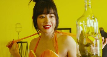 Movie still from “Antiporno” (2016), directed by Sion Sono – A young woman with red lipstick and a yellow dress; Close Up shot, Over the shoulder angle
