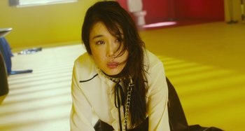 Movie still from “Antiporno” (2016), directed by Sion Sono – A woman with long black hair wearing a white shirt and a chain around her neck; Close Up shot, Low angle