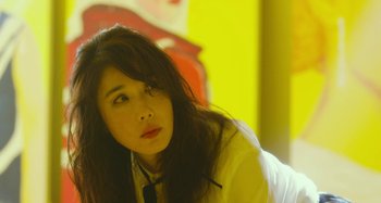 Movie still from “Antiporno” (2016), directed by Sion Sono – A woman with long black hair sitting on a couch; Close Up shot, Low angle