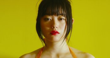 Movie still from “Antiporno” (2016), directed by Sion Sono – A person with a yellow background; Extreme Close Up shot, Low angle