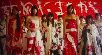 Movie still from “Antiporno” (2016), directed by Sion Sono – A group of women standing next to each other in dresses; Medium shot, Low angle