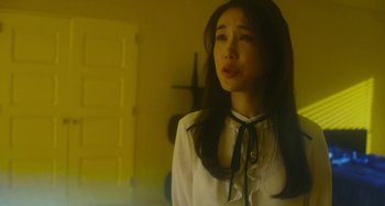 Movie still from “Antiporno” (2016), directed by Sion Sono – A woman in a white shirt and a black bow tie; Medium shot, Low angle