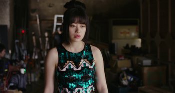 Movie still from “Antiporno” (2016), directed by Sion Sono – A young woman in a green and black sequined dress; Medium shot, High angle