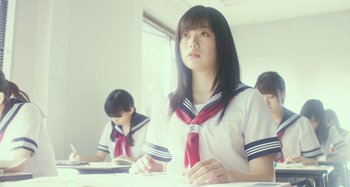 Movie still from “Antiporno” (2016), directed by Sion Sono – A girl in a school uniform sitting at a table; Close Up shot, Low angle