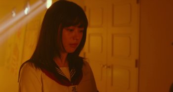 Movie still from “Antiporno” (2016), directed by Sion Sono – A woman with long black hair wearing a white shirt and a red and white scarf; Close Up shot, Low angle