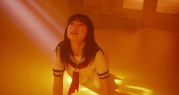 Movie still from “Antiporno” (2016), directed by Sion Sono – A woman in a sailor suit sitting on the ground; Medium shot, Low angle