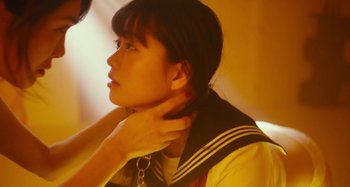 Movie still from “Antiporno” (2016), directed by Sion Sono – A young woman is touching her neck with her hand; Close Up shot, Low angle