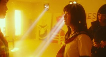 Movie still from “Antiporno” (2016), directed by Sion Sono – A woman in a yellow room with a light shining on her face; Medium shot, Low angle