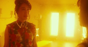 Movie still from “Antiporno” (2016), directed by Sion Sono – A woman standing in front of a window in a room; Medium shot, Low angle