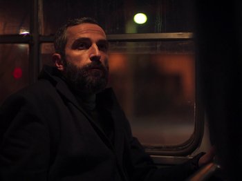 A man sitting in a car looking out the window