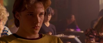 Movie still from “Apt Pupil” (1998), directed by Bryan Singer – A young man is staring at the camera; Close Up shot, Over the shoulder angle
