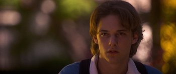 Movie still from “Apt Pupil” (1998), directed by Bryan Singer – A man with long brown hair stares into the camera; Close Up shot, Low angle