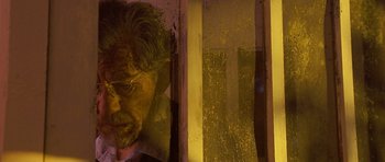 Movie still from “Apt Pupil” (1998), directed by Bryan Singer – An old man with glasses is looking out of a window; Close Up shot, Low angle