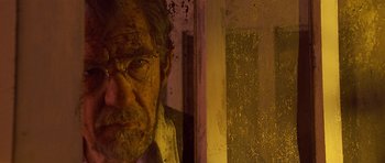 Movie still from “Apt Pupil” (1998), directed by Bryan Singer – An old man with a beard is looking out a window; Close Up shot, Low angle