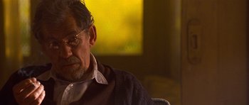 Movie still from “Apt Pupil” (1998), directed by Bryan Singer – An older man sitting in front of a window; Close Up shot, Over the shoulder angle