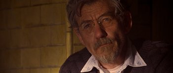 Movie still from “Apt Pupil” (1998), directed by Bryan Singer – An older man with a beard and a mustache; Close Up shot, Over the shoulder angle