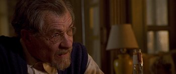 Movie still from “Apt Pupil” (1998), directed by Bryan Singer – An older man wearing glasses and a blue scarf; Close Up shot, Over the shoulder angle