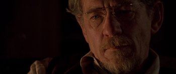 Movie still from “Apt Pupil” (1998), directed by Bryan Singer – An older man with a beard and glasses; Close Up shot, Over the shoulder angle