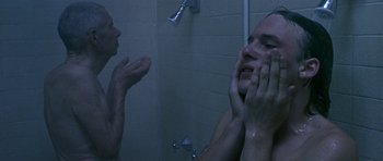 Movie still from “Apt Pupil” (1998), directed by Bryan Singer – A man in the shower looking at himself in the mirror; Close Up shot, Low angle