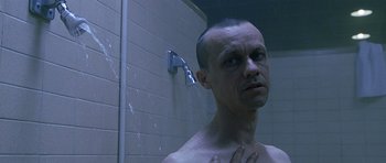 Movie still from “Apt Pupil” (1998), directed by Bryan Singer – A man in the shower looking into the mirror; Close Up shot, Low angle