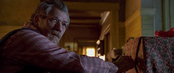 Movie still from “Apt Pupil” (1998), directed by Bryan Singer – An older man wearing glasses sitting in front of a window; Close Up shot, Over the shoulder angle